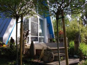 una casa con un porche de madera con un banco. en Holiday home NurMeer, en Ahrenshoop