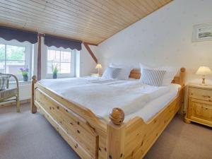 a large wooden bed in a bedroom with a wooden ceiling at Holiday apartment sunrise in Dänschendorf