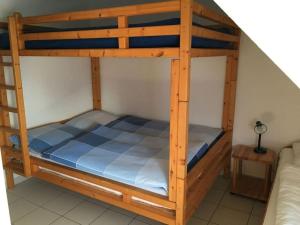 a bunk bed with a wooden bunk bed frame at Holiday house house sound of the sea in Borkum