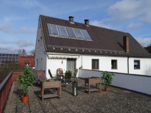 une maison blanche avec des panneaux solaires sur le toit dans l'établissement Ferienwohnung Dorothea, à Kulmbach