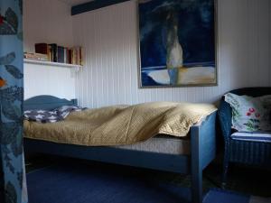 a bedroom with a bed and a painting on the wall at Romantic thatched roof house in Schnarup-Thumby