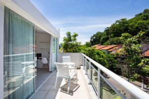 a balcony of a house with two chairs on it at Apartamento a 500 m da Praia de Itacoatiara in Niterói