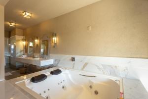 a large bathroom with a tub and two sinks at Quinta dos Manacás Pousada - Pedra Azul - Rota dos Lagos in Pedra Azul