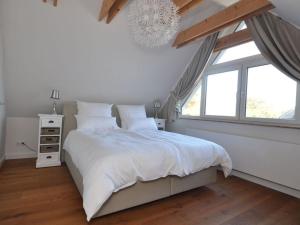 Un dormitorio con una cama blanca y una ventana. en Holiday house dune forest b, en Dierhagen