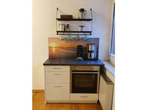 eine Küche mit einer Arbeitsplatte und einer Kaffeemaschine in der Unterkunft Holiday apartment wind force 8 in Langeoog