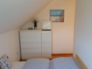 sypialnia z łóżkiem i komodą w obiekcie Holiday apartment wind force 8 w mieście Langeoog