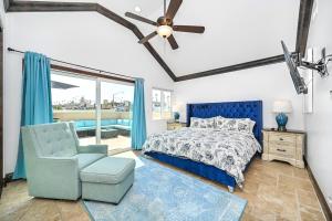 Un dormitorio con una cama azul y una silla. en 3 Bedroom Luxury Home Steps to Balboa Fun Zone, en Newport Beach