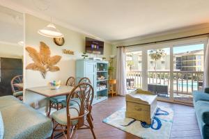 a living room with a couch and a table and chairs at Bright Galveston Condo with Balcony and Gulf Views! in Galveston