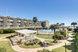 a view of an apartment complex with a pool at Bright Galveston Condo with Balcony and Gulf Views! in Galveston