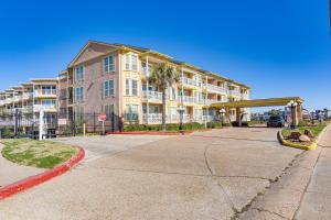 - un grand immeuble dans une rue avec un panneau d'arrêt dans l'établissement Galveston Condo with Large Balcony Walk to Beach!, à Galveston