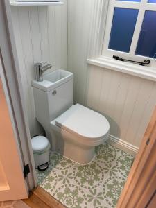ein Bad mit einem WC und einem Fenster in der Unterkunft The Hut by the River in York