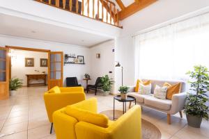 a living room with yellow chairs and a table at Casa Lali Habitación 2 in Las Lagunas