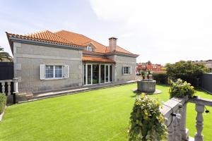 a house with a green yard with a fence at Casa Lali Habitación 2 in Las Lagunas