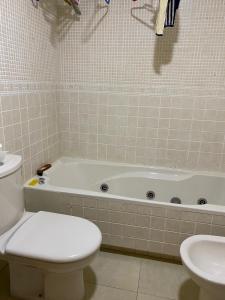 a bathroom with a tub and a toilet and a sink at C.Grafito 22 in Torrejón de Ardoz