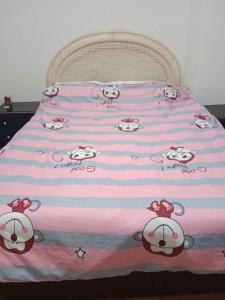 Una cama con una manta de hola Kitty. en C.Grafito 22, en Torrejón de Ardoz