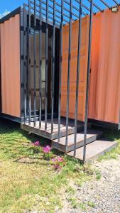 a building with a fence on the side of it at Cubil Naranja. Casa conteiner 2 dormitorios in General Roca