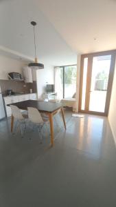a kitchen and dining room with a table and chairs at Cubil Naranja. Casa conteiner 2 dormitorios in General Roca +10 photos