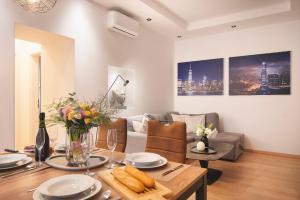 sala de estar con mesa y sofá en Arta Apartments City Center - with Private Parking en Pula