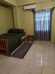 a bedroom with a bed and a window and a rug at Pryme Paradise in Carnbee Village