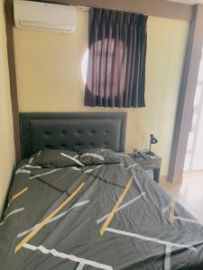 um quarto com uma cama com um edredão cinzento em salome apart em Tarapoto
