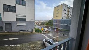 einen Balkon mit Blick auf eine Straße mit einem Auto in der Unterkunft Ap Central Chic in Odivelas