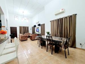 a living room with a table and chairs and a couch at Villa Sampaguita 4bedroom Private Villa in Kampong Alor Gajah