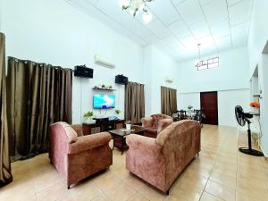 a living room with two chairs and a table at Villa Sampaguita 4bedroom Private Villa in Kampong Alor Gajah