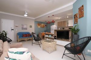 - un salon avec un canapé et une télévision dans l'établissement Apartamento Praia do Tombo Guarujá 120m do mar, à Guarujá