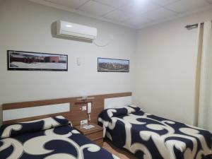 a room with two beds and a air conditioner at Hostal Restaurante el Paraíso in Don Benito