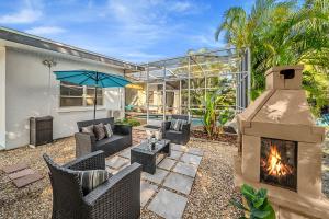 a patio with a fireplace and chairs and a house at Fantastic Island House 1 mile to the beach with heated pool in Sarasota
