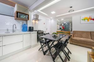 uma cozinha e sala de estar com mesa e cadeiras em Bombinhas Summer Beach em Bombinhas