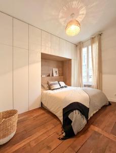 a bedroom with a large bed and a chandelier at Why Paris ? Why Montmartre ? in Paris