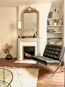 a living room with a fireplace and a mirror at Why Paris ? Why Montmartre ? in Paris