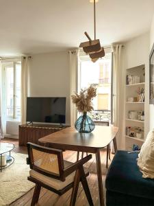 a living room with a table and a tv at Why Paris ? Why Montmartre ? in Paris