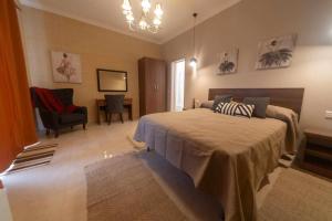 a bedroom with a large bed and a chair at Casa Maria Pia in Nadur