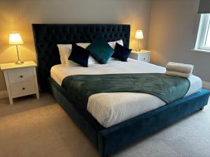 - un grand lit avec une tête de lit noire dans une chambre dans l'établissement The Happy Heron, à Donegal