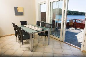 a dining room with a table and chairs and a balcony at Mones Feriesenter in Mandal