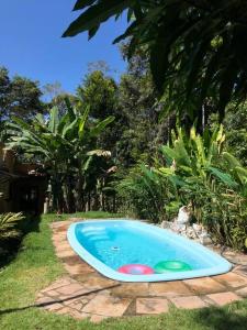 een zwembad met twee frisbees in een tuin bij Chalé encantado Ambika eco Arraial d Ajuda in Porto Seguro