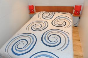 a bed with a blanket with spirals on it at Heliactida House in Ormos Panagias