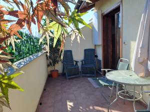 un patio con sedie e un tavolo sul balcone. di Casa Poli a Torino