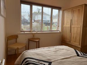 - une chambre avec un lit, une chaise et une fenêtre dans l'établissement Saltdean Stay, à Brighton et Hove