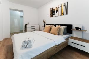 een slaapkamer met een groot wit bed en slippers. bij Sandra in Boekarest