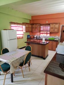 a kitchen with a table and chairs and a refrigerator at Pryme Paradise in Carnbee Village