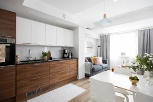 a kitchen with white cabinets and a dining room at Stylish Flat in Trendy Kallio in Helsinki