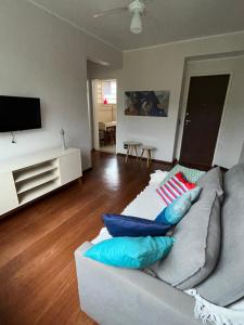 a living room with a couch and a television at Apartamento Centro ao lado do Country Club in Nova Friburgo