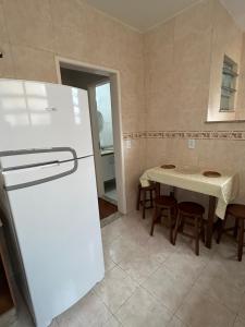 a kitchen with a refrigerator and a table with chairs at Apartamento Centro ao lado do Country Club in Nova Friburgo