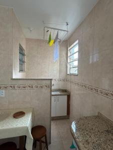 a kitchen with a sink and a table in a room at Apartamento Centro ao lado do Country Club in Nova Friburgo