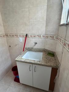 a bathroom with a sink and a red mop at Apartamento Centro ao lado do Country Club in Nova Friburgo