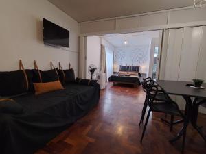sala de estar con sofá negro y mesa en Apartment City Heart en Mendoza