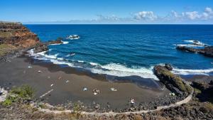 un grupo de personas en una playa cerca del océano en Mar & Teide, en Sauzal